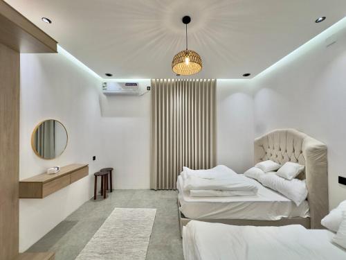 ein Schlafzimmer mit zwei Betten und einem Spiegel in der Unterkunft سَروة للوحدات السكنية in Abha