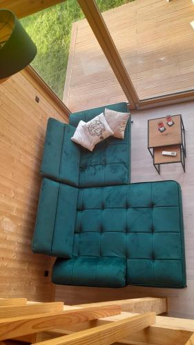 Een bovenaanzicht van een groene bank met een tafel. bij Villa Leone in Nowe Warpno