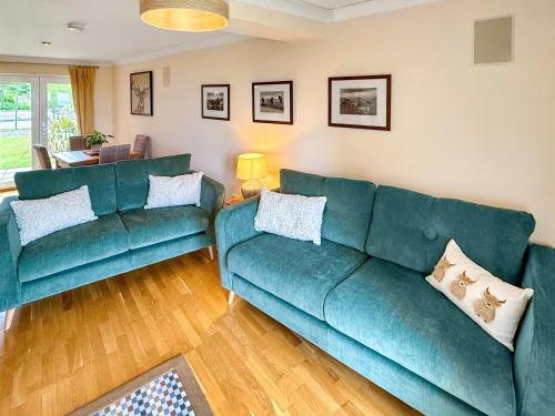 a living room with two green couches at No4 The Links Apartments in Brora