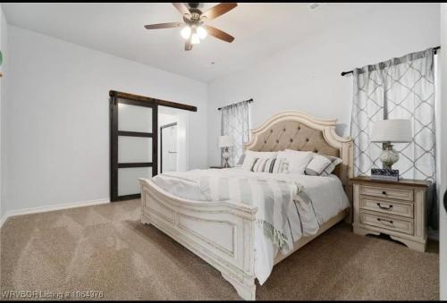 a bedroom with a white bed and a ceiling fan at My house your house in Fort Smith