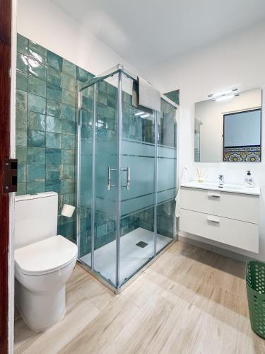 a bathroom with a glass shower and a toilet at La Centenaria 1920 in Telde