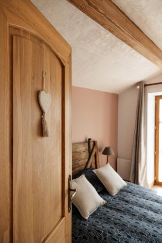 a bedroom with a bed with a wooden door at Le Logis du Vieux Donjon in Châteaumur