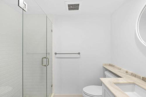 a bathroom with a shower and a toilet and a sink at Elegant Three-Bedroom Oceanfront Apartment with Designer Finishes in South Palm Beach