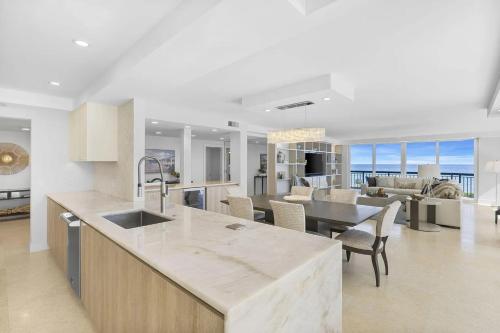 a kitchen and living room with a table and chairs at Elegant Three-Bedroom Oceanfront Apartment with Designer Finishes in South Palm Beach