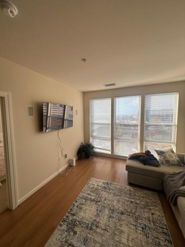 ein Wohnzimmer mit Couch und großem Fenster in der Unterkunft Modern& stylish vibe in Fairfax