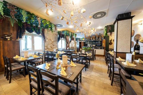 Un restaurante con mesas y sillas en una sala. en ACHAT Hotel Leipzig Messe, en Leipzig