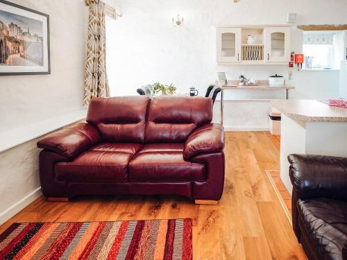a brown leather couch sitting in a living room at Flemish Cottage - Uk6720 in Lydstep
