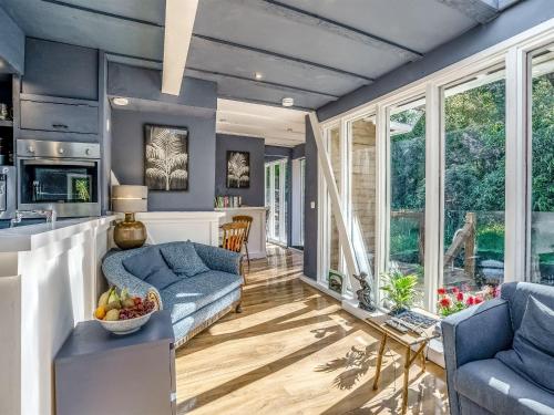 a kitchen and living room with blue walls and windows at The Berm - Uk41199 in Llanfynydd