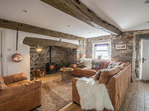 ein Wohnzimmer mit Sofas und einer Steinmauer in der Unterkunft Bwlchgroes in Dinas