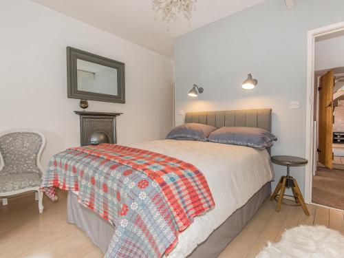 ein Schlafzimmer mit einem Bett, einem Stuhl und einem Spiegel in der Unterkunft Bwlchgroes in Dinas