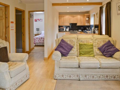 a living room with a couch and purple and green pillows at Beech Cottage - E4779 in Atwick