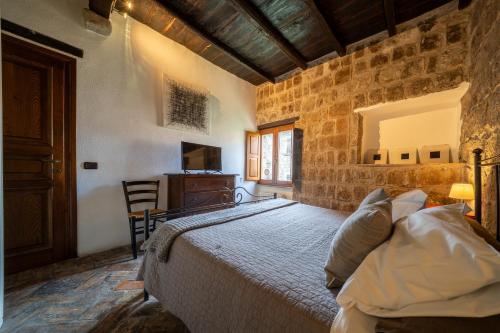 a bedroom with a large bed in a stone wall at La Suite del Borgo in Viterbo
