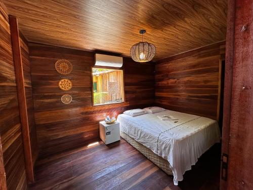 a bedroom with wooden walls and a bed in a room at Hotel e Restaurante Tribo Combú in Belém