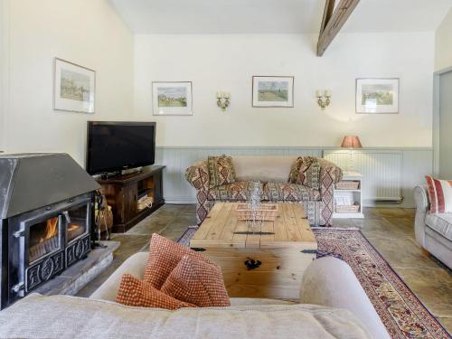 a living room with a couch and a fireplace at Stable Cottage - E5118 in West Burton