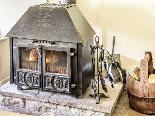 an old wood stove on a table in a room at Stable Cottage - E5118 in West Burton
