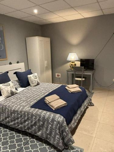 1 dormitorio con cama con sábanas azules y escritorio en APARTAMENTO FONTE DO CRISTO, en Porriño