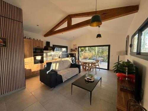 ein Wohnzimmer mit Sofa und Tisch in der Unterkunft Le jardin de la Vade in Carcassonne