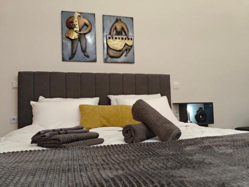 a bedroom with a bed with three pictures on the wall at Kerkétio guesthouse in Tríkala