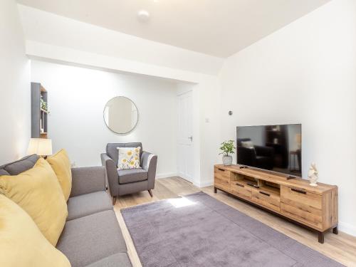 ein Wohnzimmer mit Couch und Flachbildfernseher in der Unterkunft Dove Cottage in Inverness