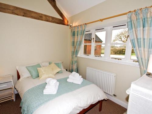 a bedroom with a bed with towels on it at The Peacock Barn - E4713 in Dunstall