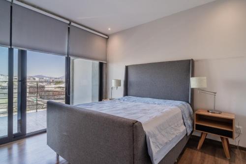 a bedroom with a large bed and a large window at Elegante apartamento 3 recamaras Juriquilla in Juriquilla