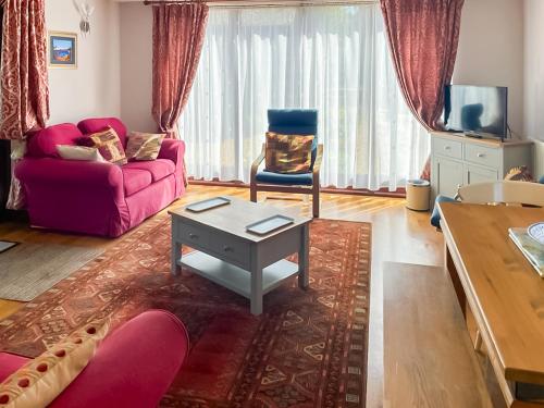 a living room with a purple couch and a table at Pheasant in Welney