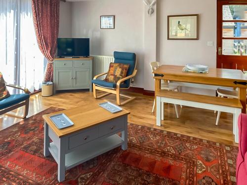 a living room with a table and a desk at Pheasant in Welney
