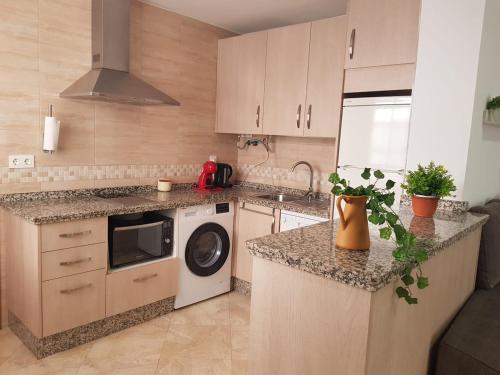 a kitchen with a washing machine and a dishwasher at Apartamento completo en Almonte centro con terraza in Almonte