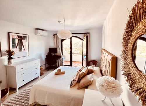 a bedroom with a bed and a dresser and a mirror at Casa de Ensueño - exklusive Villa mit 3 Schlafzimmern, 3 Bädern, 4 Terrassen mit Panoramaausblick in Atamaría