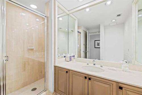 a bathroom with a shower and a sink and a mirror at Spacious Three-Bedroom Oceanfront Apartment with Panoramic Views in Pompano Beach
