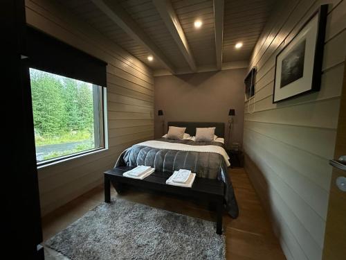 ein Schlafzimmer mit einem Bett und einem Tisch und einem Fenster in der Unterkunft Naava Resort Luppo - Upea huvila järvinäkymällä in Ähtäri