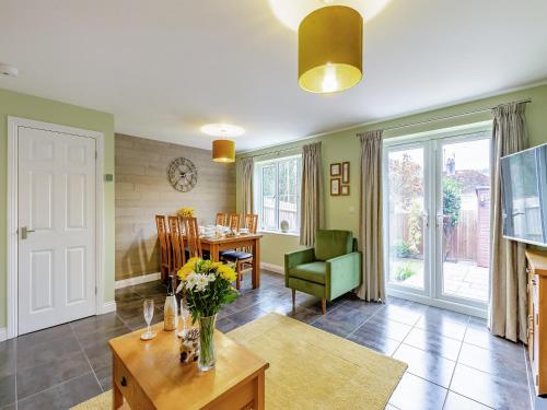a living room with a vase of flowers on a table at Humbug House in Lower Soudley