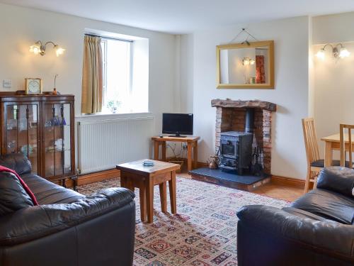 a living room with two couches and a fireplace at Dragon Fly Cottage in Brompton