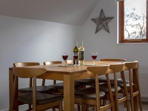 ロクサムにあるGrebeのワイングラスが置かれた木製のテーブルと壁に飾られた星