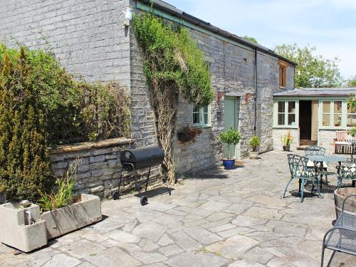 a patio with a grill next to a brick building at The Tack Room - Uk30438 in Kingsbury Episcopi