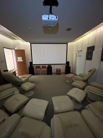 a waiting room with chairs and a projection screen at Jibuzaka Village Hotel in Achi