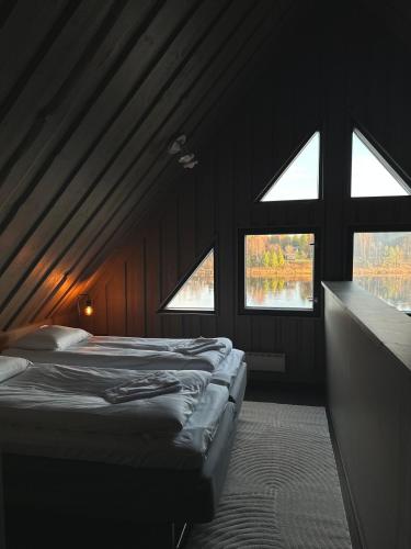 a bedroom with two beds and two windows at Shaman Village - Resort & Glass Igloos in Rovaniemi