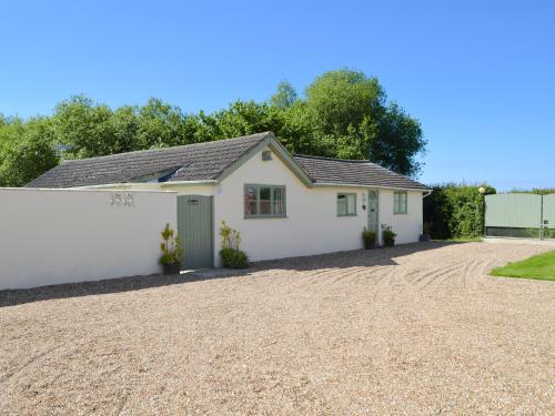 a white garage with a gravel driveway at The Chicken Shed in Ruckinge