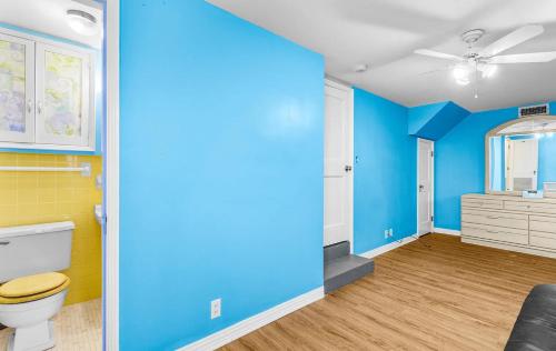 ein Badezimmer mit blauen Wänden und einer Toilette und einem Waschbecken in der Unterkunft Luxury Five-Bedroom Riverfront Villa with Private Pool in Daytona Beach