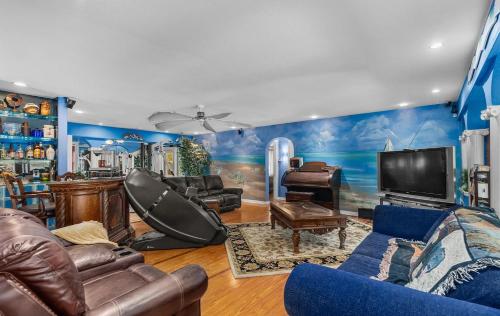 ein Wohnzimmer mit Ledermöbeln und einem TV in der Unterkunft Luxury Five-Bedroom Riverfront Villa with Private Pool in Daytona Beach