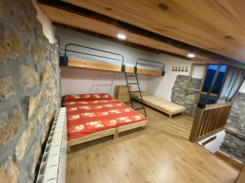 a room with two bunk beds and a stone wall at Casa Narcís in Claverol