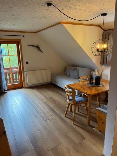 a living room with a table and a bed at Ferienwohnung Lahnerhof in Arriach