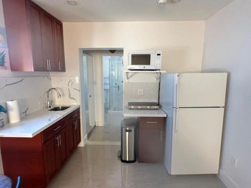 uma cozinha com uma geladeira branca e um micro-ondas em Miramar's Studio em Miramar