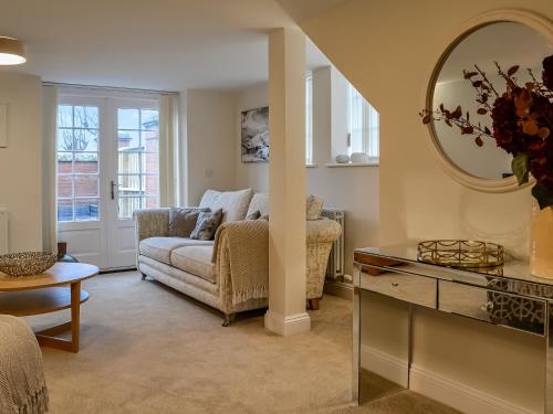 een woonkamer met een bank en een spiegel bij The Police Station - Uk45642 in Silloth