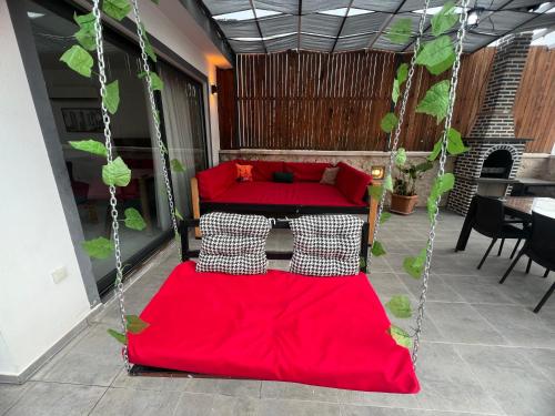 two beds on a porch with red sheets at Villa karya in Kas