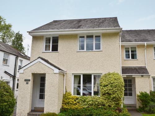 a house with white windows and bushes at Haystacks in Bowness-on-Windermere