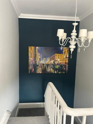 a hallway with a staircase with a painting on the wall at Dotty Apartment in Birtley