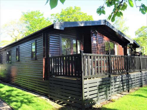 a log cabin with a porch and a deck at Bewick Lodge in Keswick