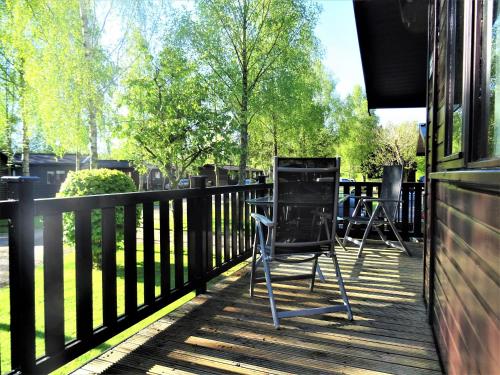 a pair of chairs sitting on the porch of a house at Bewick Lodge in Keswick