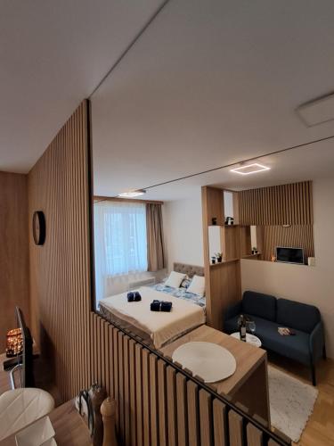 a hotel room with a bed and a couch at Apartman Pahuljica in Pale